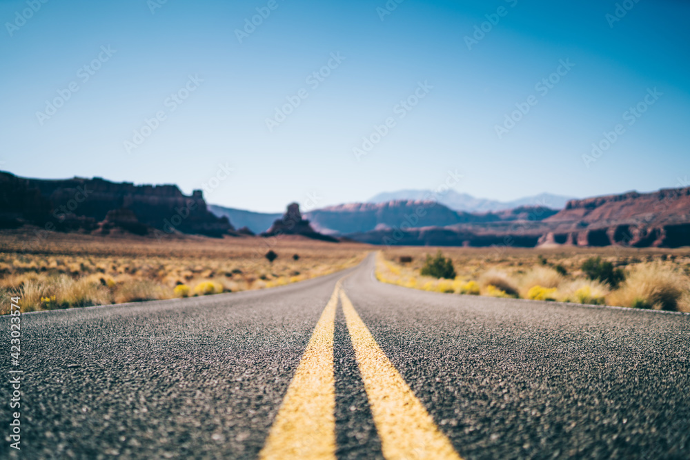 Long empty asphalt road in dry valley in USA