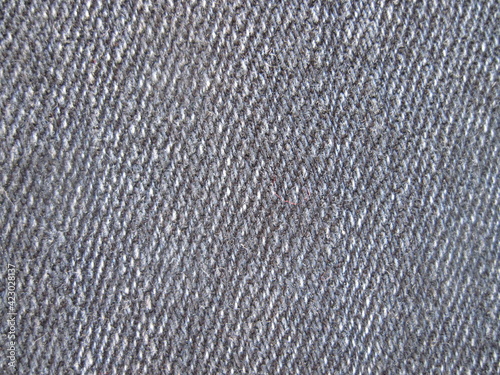 close up of jeans. Natural knitted textile backdrop in gray colors. grey carpet texture. black and white textured background 