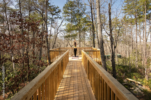 Wallpaper Mural Women doing yoga on wood deck in the woods overlooking mountains. Torontodigital.ca