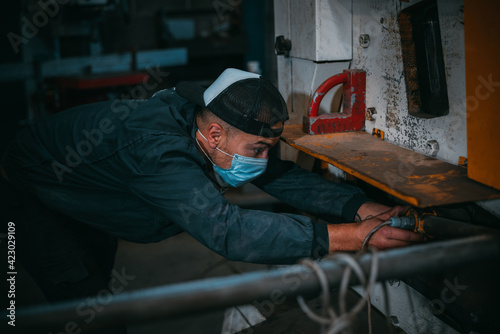 adult man in uniform works in an industry with machinery