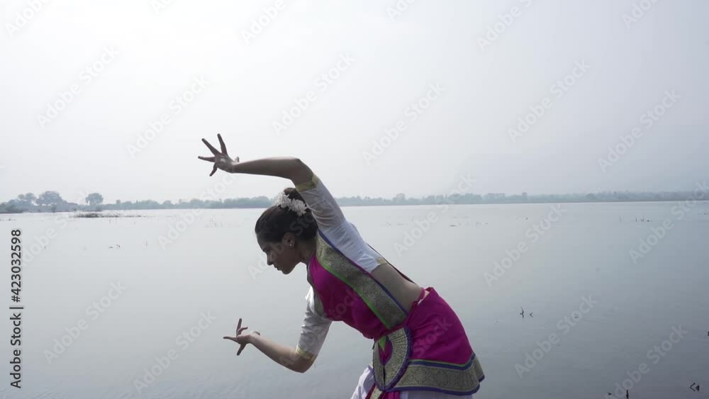 A bharatnatyam dancer displaying a classical bharatnatyam pose in the nature of  Vadatalav lake, Pavagadh. Beautiful indian girl dancer in the posture of Indian classical dance bharatanatyam .