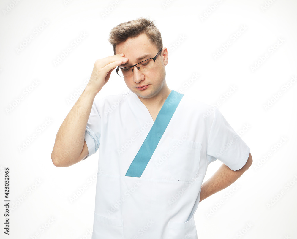 Medicine COVID-19 concept. Handsome doctor man wearing medical uniform over white background tired rubbing forehead, feeling fatigue and headache.