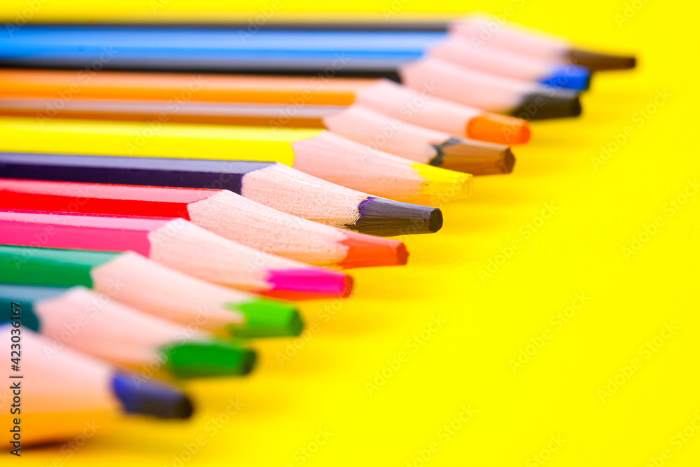 Background, blur, out of focus, bokeh. Colored pencils isolated on a yellow background. The concept of creativity development. Background, blur, out of focus, bokeh. Colored pencils isolated on a yellow background. The concept of creativity development.