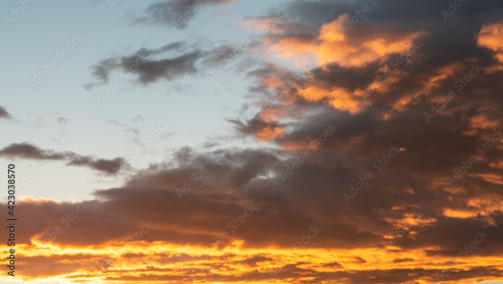 Sunset sky with dramatic orange clouds. Nature sky clouds background.
