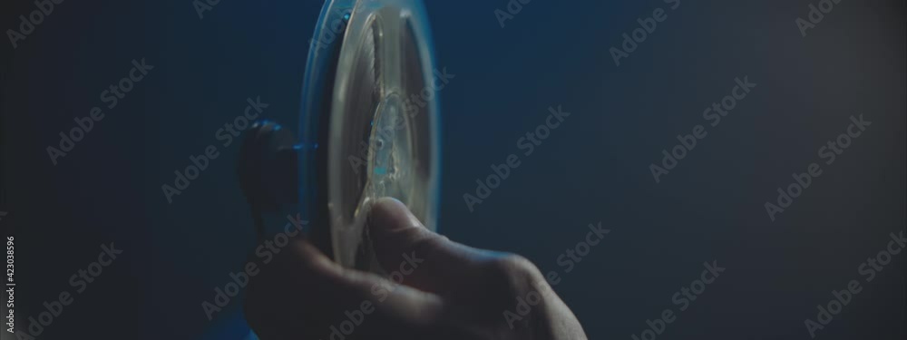 Male Hands putting the film reel on the Vintage Projector.