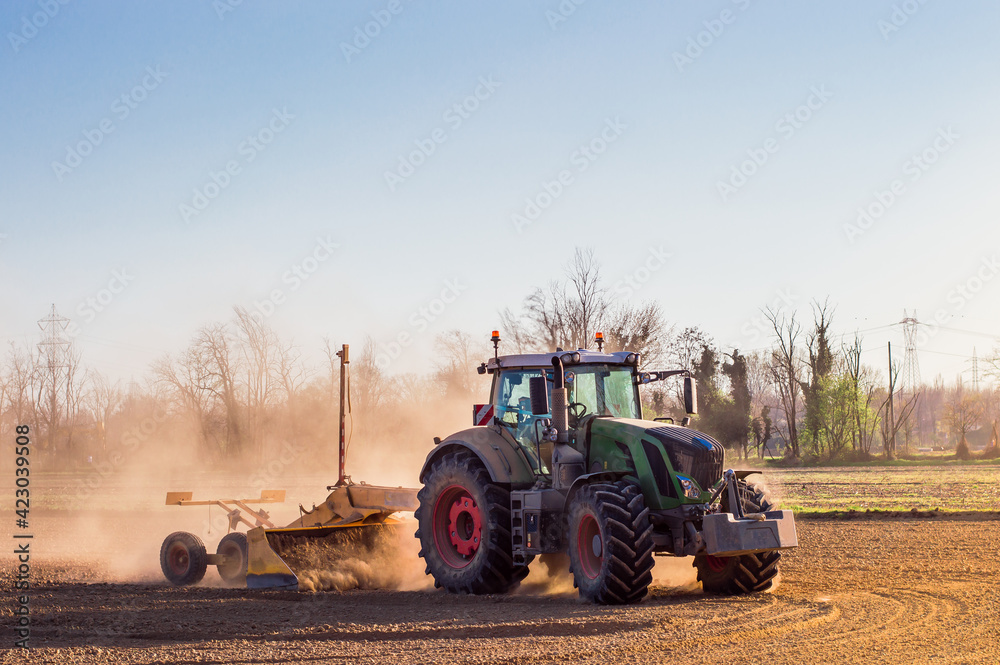 Fototapeta premium Tractor working in the field, preparing the land for planting