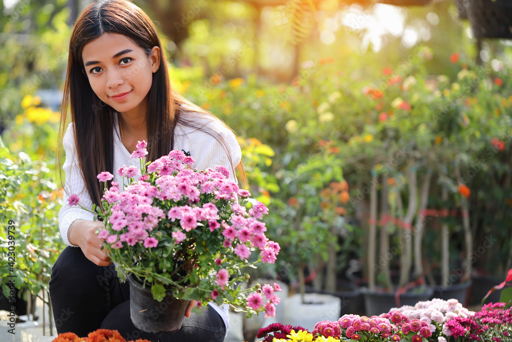 A woman looking at the flowers in a pot to buy and decorate the garden.