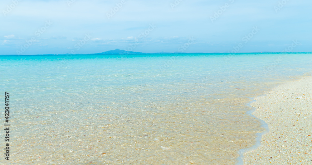 Soft blue ocean wave on clean sandy beach
