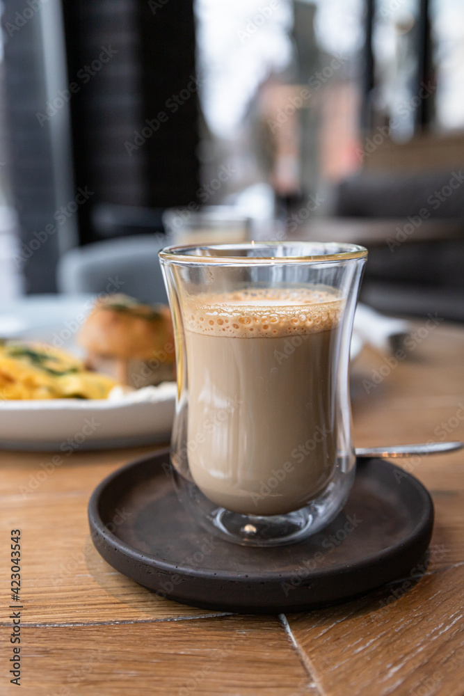 Glass cup with cappuccino on wooden table in cafe. Glass cup with cappuccino on wooden table in cafe.