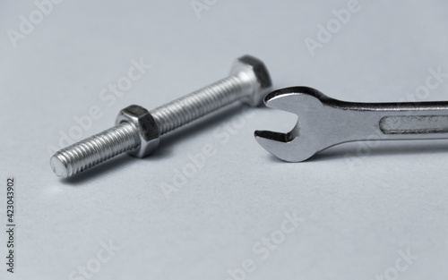 screw-nut of different sizes, bolts and adjustable spanner. White background. Concept.