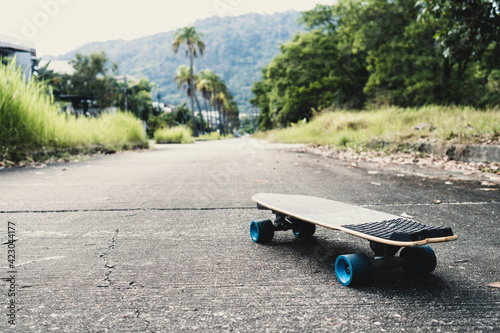 Longboard or skateboard on the road and pathway in park. Outdoor activities.
