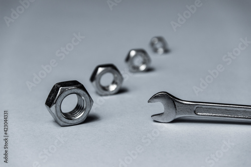 screw-nut of different sizes, bolts and adjustable spanner. White background. Concept.