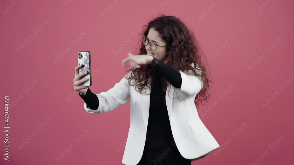 Beautiful teen with curly hair, talking to friends on the phone with the help of the front camera. Beautiful teen with curly hair, talking to friends on the phone with the help of the front camera.