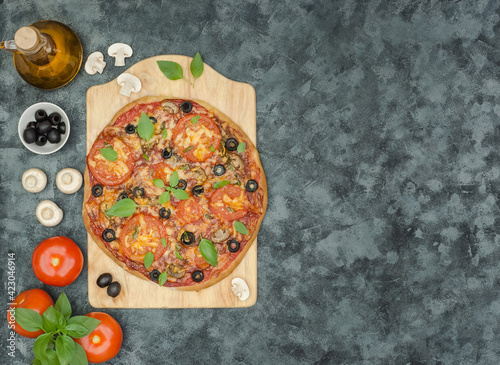 Homemade pizza with mushrooms, olives on black background with copy space