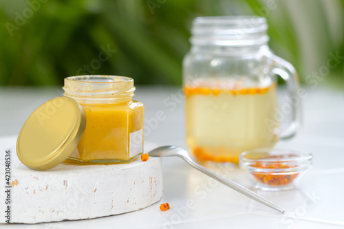 jar of honey with sea buckthorn and a drink with sea buckthorn