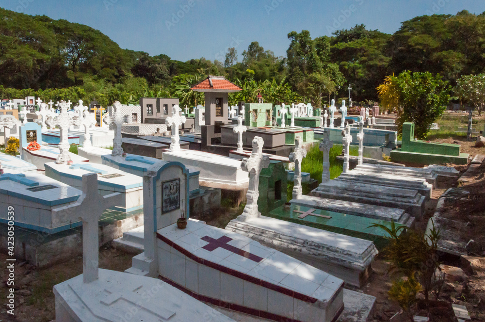 Fototapeta premium Christlicher Friedhof in Asien. Besonders schön gearbeitete steinerden Gräber . Diese sind mit Fliesen belegt und mit Kreuzen verziert.