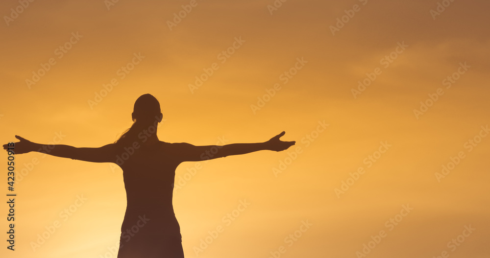 Happy confident woman with arms outstretched tot the sky.   