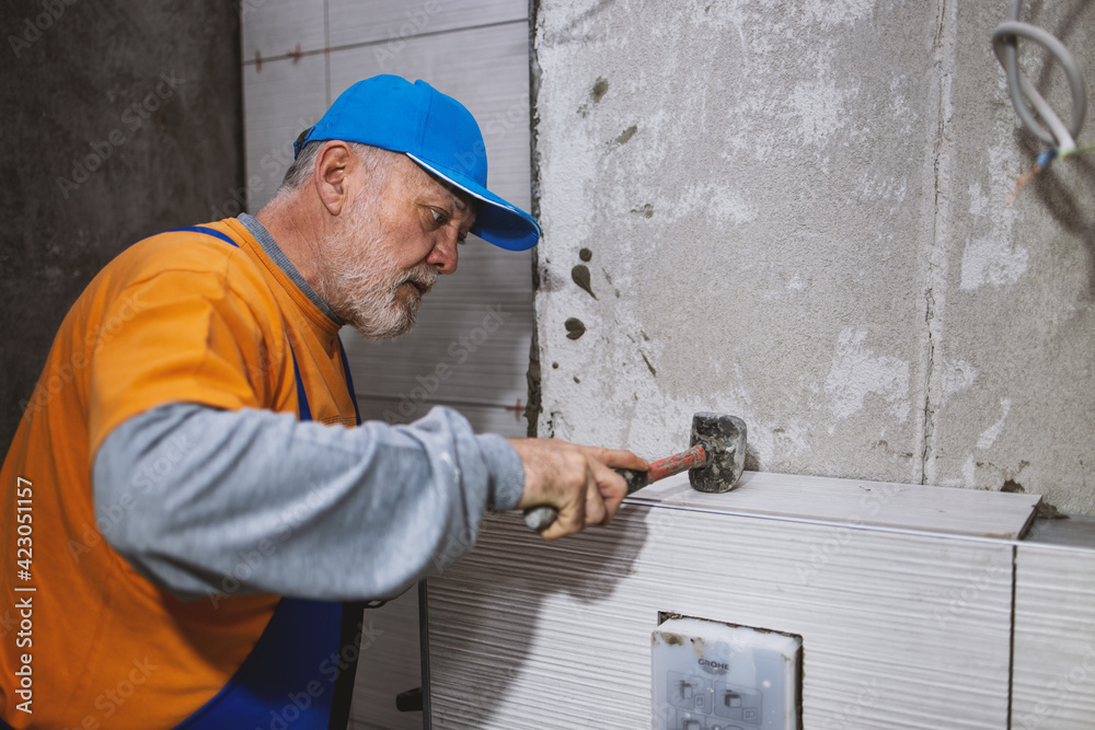 Handyman installing ceramic tiles in brand new building Handyman installing ceramic tiles in brand new building