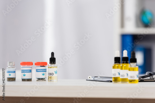 bottles with medical cannabis and cbd lettering near clipboard on desk