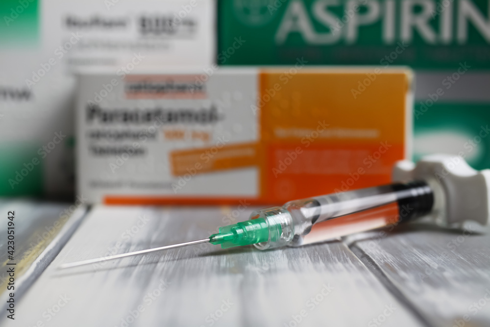 Viersen, Germany March 1. 2021 Closeup of covid19 vaccine syringe with packets of aspirin