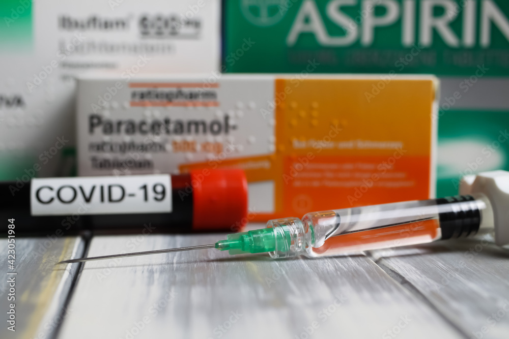 Viersen, Germany March 1. 2021 Closeup of covid19 vaccine syringe with packets of aspirin