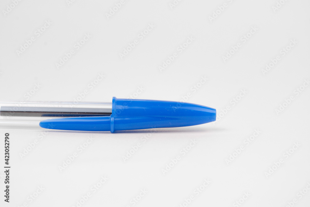 Ballpoint pen with a blue cap on a white background, side view, half ballpoint pen, photo for advertising. Ballpoint pen with a blue cap on a white background, side view, half ballpoint pen, photo for advertising.