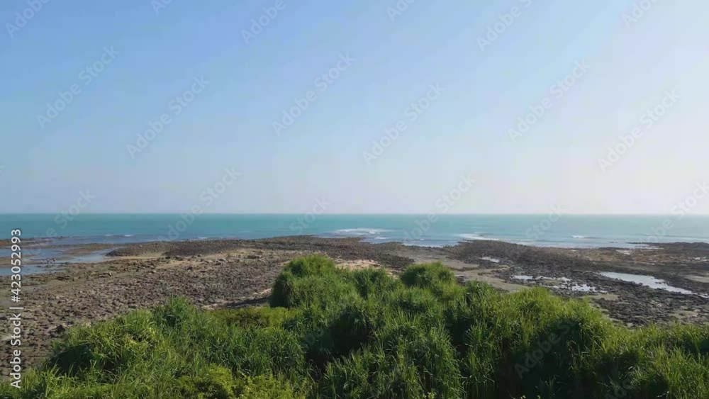 Rocky coastline, green landscape and light blue water in aerial view Rocky coastline, green landscape and light blue water in aerial view