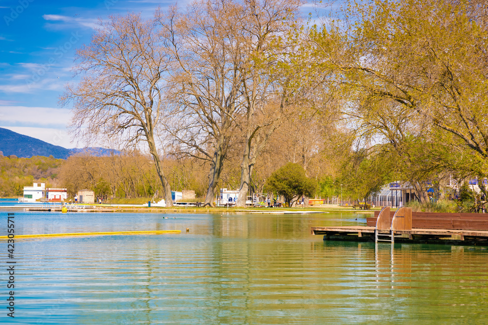 Panoramic view of Lake Banyoles with one of the old boathouses, recently restored as a bar terrace. Banyoles, Catalonia, Spain