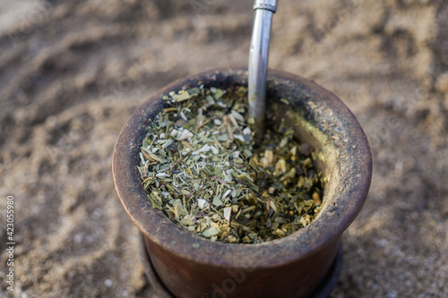 Detail of Yerba mate dry leafs in calabash with bombilla, popular in latin america.