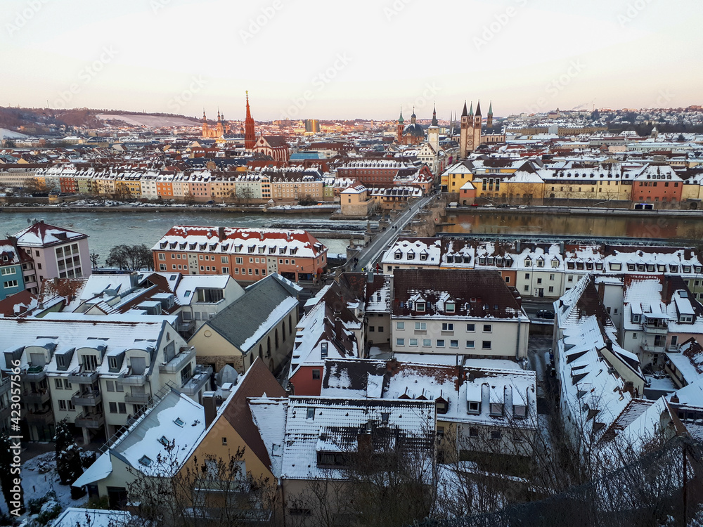 Cityscape of Wuerzburg with building roofs covered in the snow and Alte Mainbrücke in Würzburg, Germany