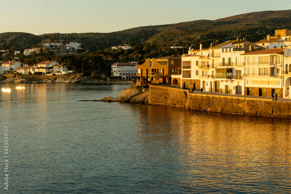 Marvelous sunrise at beautiful costal town Cadaques at Catalonia, Spain. Cosy houses on the Mediterranean sea light by the warm rising sun with cliff.  Serenity and off season vacation. 
