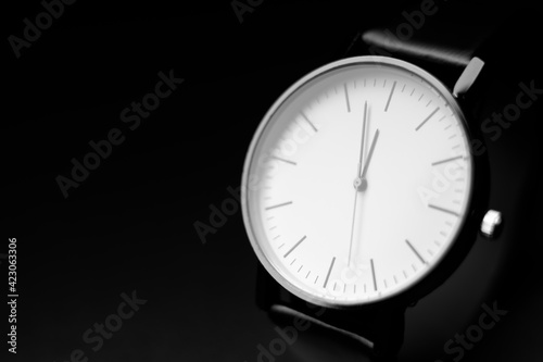 white modern analog wristwatch on a black background