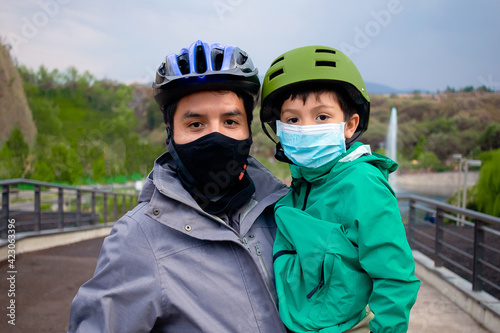 Padre e hijo latinos con cubrebocas y caso en parque exterior cuidado covid 2