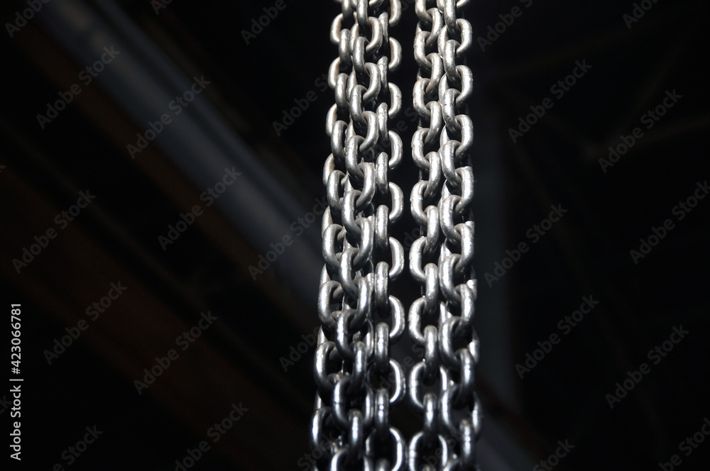 Metal chains dangling and illuminated with bright light. Metal chains dangling and illuminated with bright light.