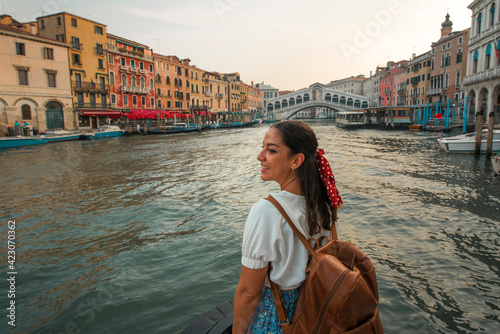Happy young girl traveling in venice with rialto bridge in background