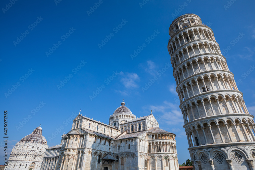 The Leaning Tower of Pisa, campanile, or freestanding bell tower, of the cathedral of the Italian city of Pisa. Blue sky.