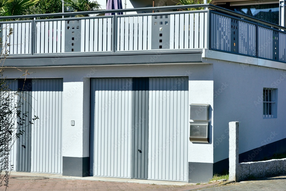 Moderne Beton-Garage mit Automatik-Tor in der Wohngebäude-Zufahrt