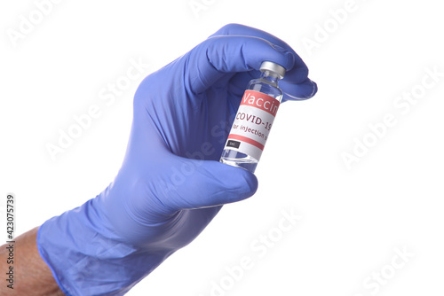 Close up of a hand in a blue latecx surgical glove holding a vial of Covid-19 Vaccine.