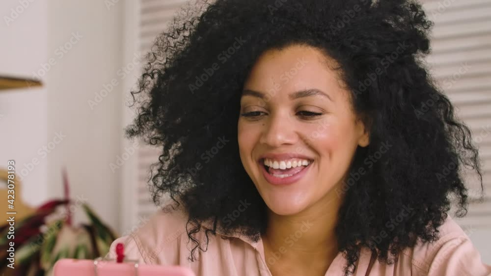 Cute African American woman communicates on a video call using a mobile ...