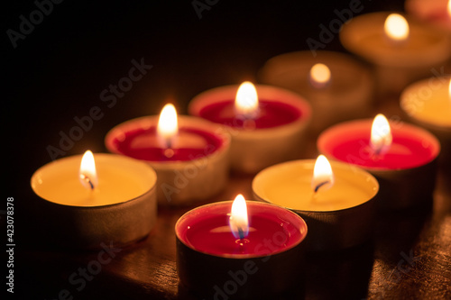 background with tea light candles shines in the dark.