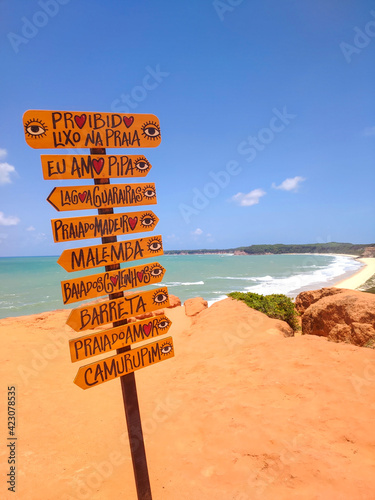 Direction signs in the sand with beach in the background © Djalma