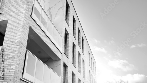 Part of city real estate property and condo architecture. Detail in modern residential flat apartment building exterior. Fragment of new luxury house. Black and white.
