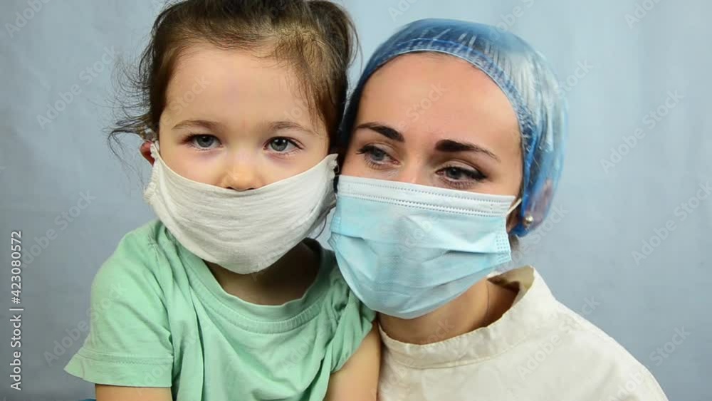 Doctor and masked child close up. The doctor receives children during the coronavirus pandemic. Close-up of a doctor and a child in protective masks. Pediatrician consultation. Doctor and masked child close up. The doctor receives children during the coronavirus pandemic. Close-up of a doctor and a child in protective masks. Pediatrician consultation.
