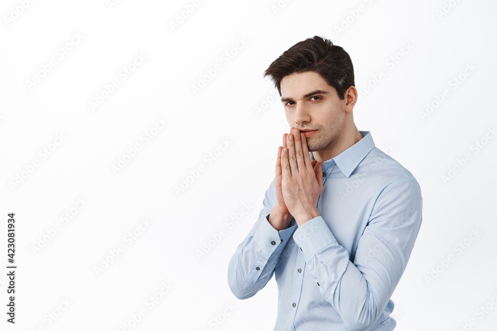 Ceo corporate man, businessman praying, holding hands in pray, looking at camera with anticipation and serious face, begging, standing over white background Ceo corporate man, businessman praying, holding hands in pray, looking at camera with anticipation and serious face, begging, standing over white background