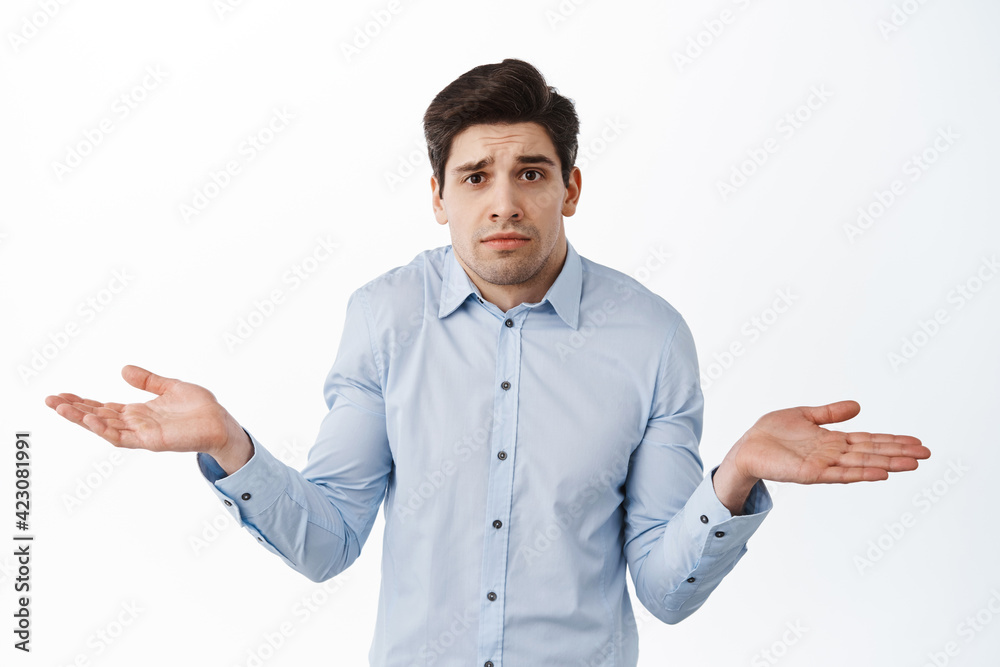 I dont know. Clueless corporate guy, office worker shrugging shoulders and look confused, standing puzzled against white background