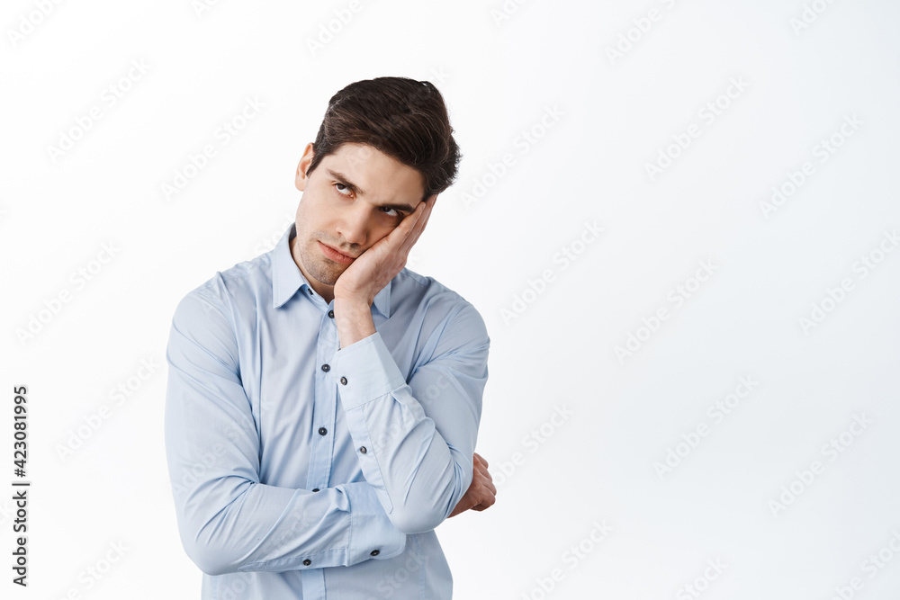 Annoyed office worker look aside with angry irritated face, lean on hand pissed-off, have under eye dark circles, standing bothered against white background Annoyed office worker look aside with angry irritated face, lean on hand pissed-off, have under eye dark circles, standing bothered against white background