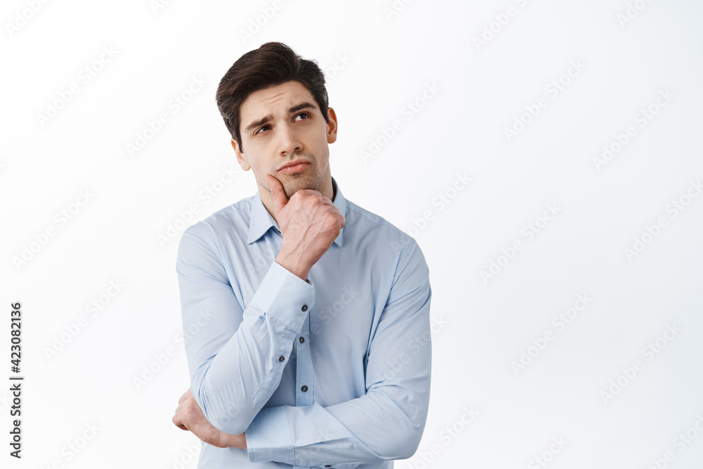 Corporate man, office manage thinking, looking aside and making choice, standing thoughtful against white background Corporate man, office manage thinking, looking aside and making choice, standing thoughtful against white background
