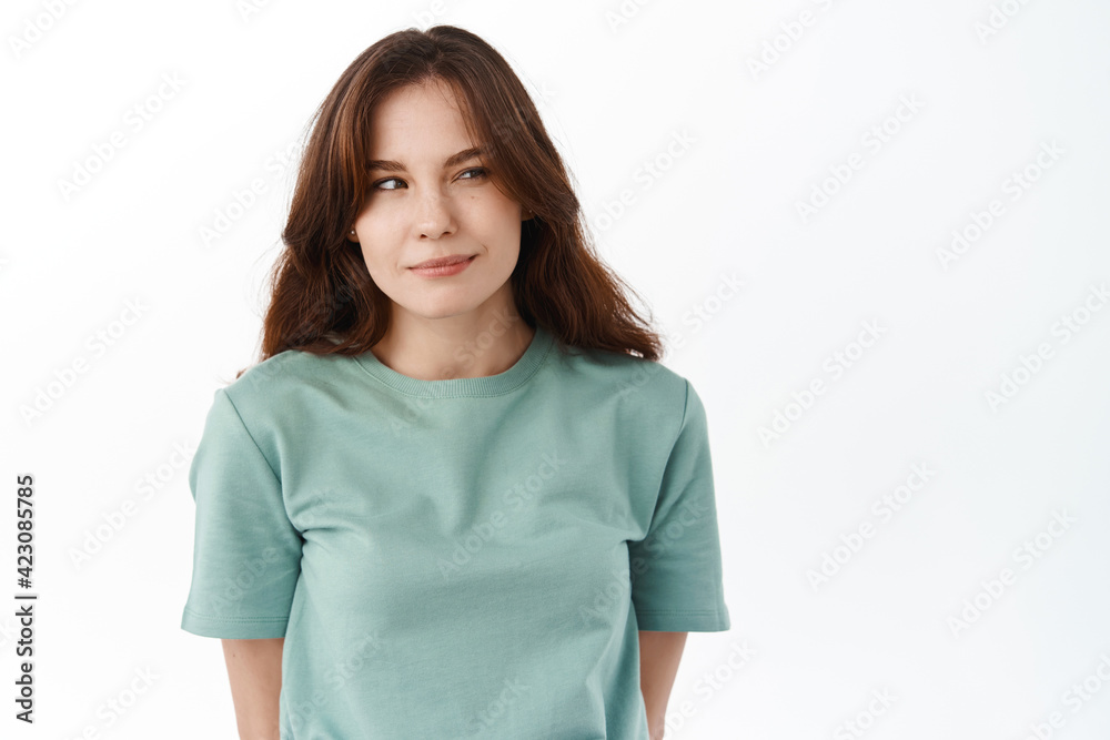 Thoughtful young woman looking aside at logo banner with intrigued smile, squinting and thinking, standing against white background Thoughtful young woman looking aside at logo banner with intrigued smile, squinting and thinking, standing against white background