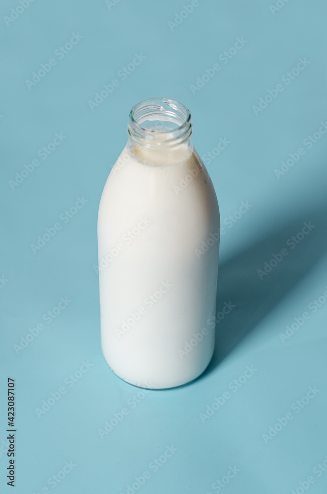 Milk bottle in pop art style on a blue background. Minimalism, vertical orientation Milk bottle in pop art style on a blue background. Minimalism, vertical orientation
