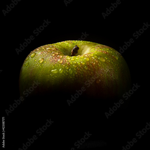 apple on black phoe with drops of water photo